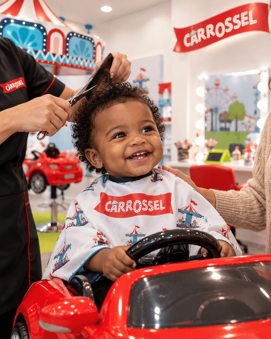 Bebé a sorrir enquanto lhe cortam o cabelo, sentado no carro vermelho do Carrossel